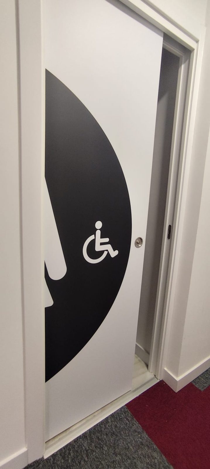 Puerta de baño adaptado para personas con movilidad reducida en oficinas de Madrid