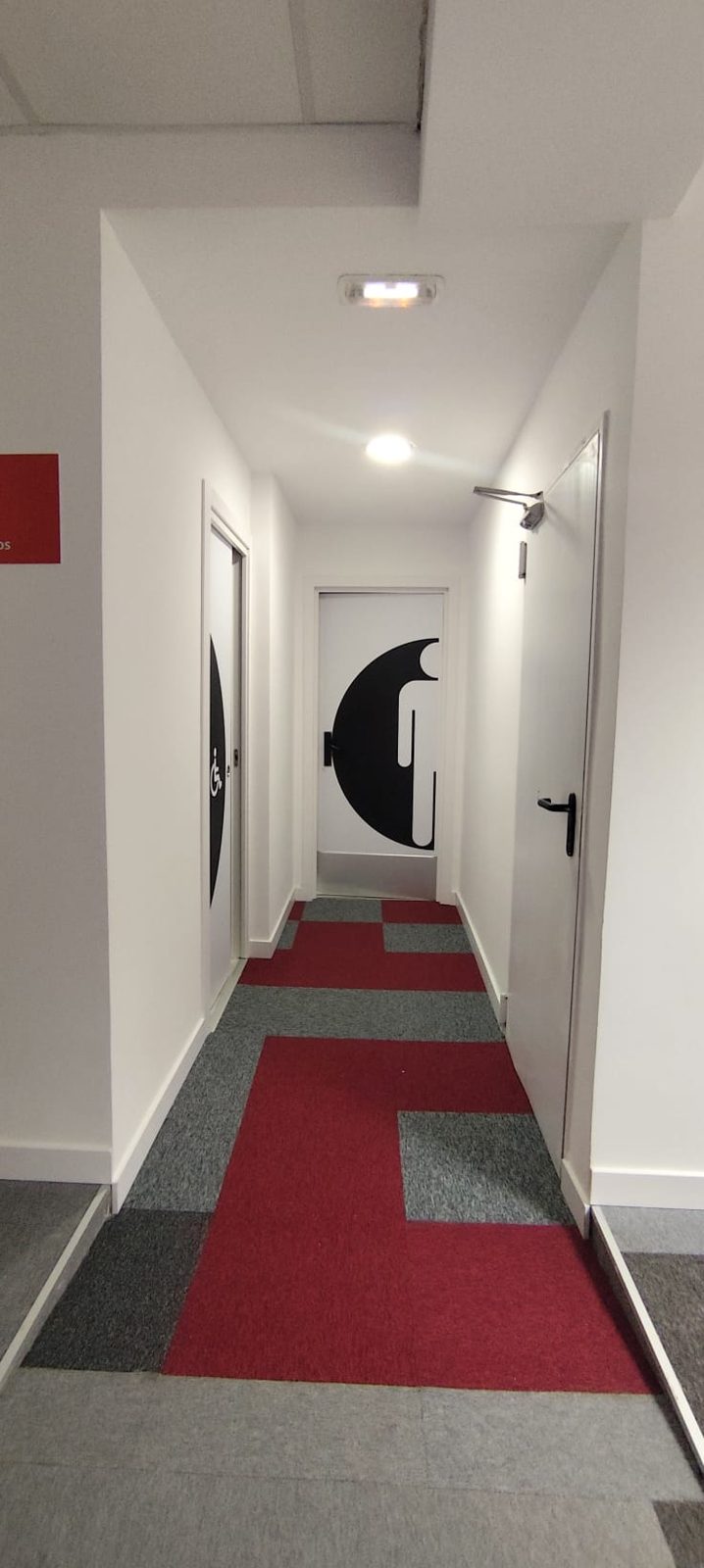 Pasillo pintado con los colores de marca de Save the Children en Madrid